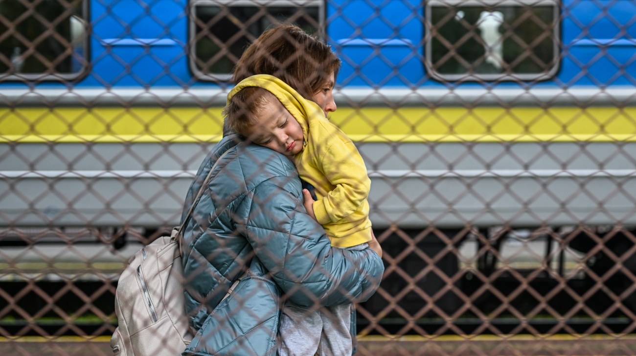 Паспорт зі штампом про виїзд з України поряд із прапорами ЄС та України