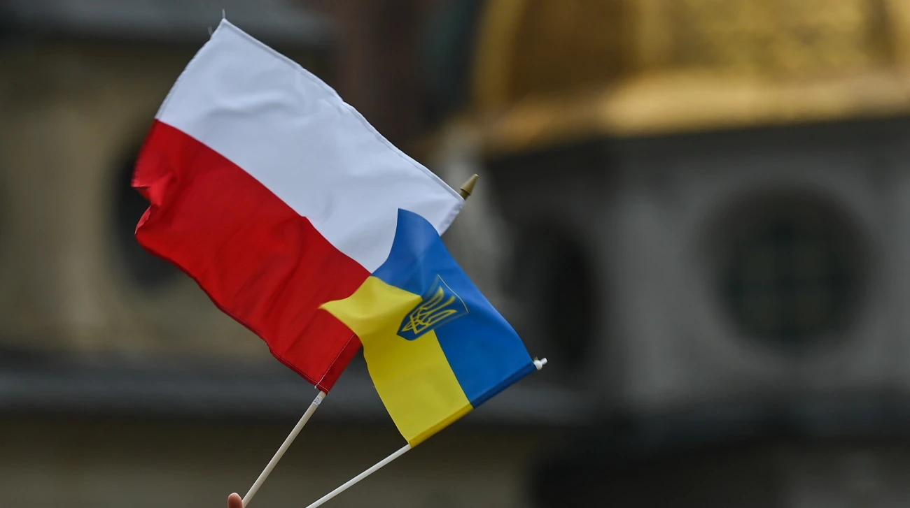 Прапор Польщі та мітинг біля будівлі у Варшаві